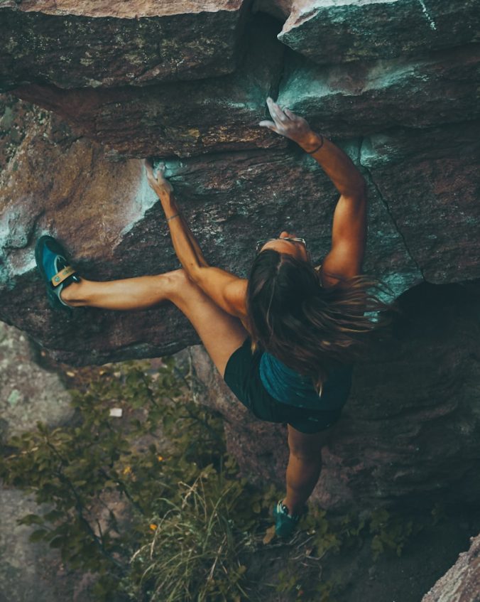 photo of woman climbing mountain