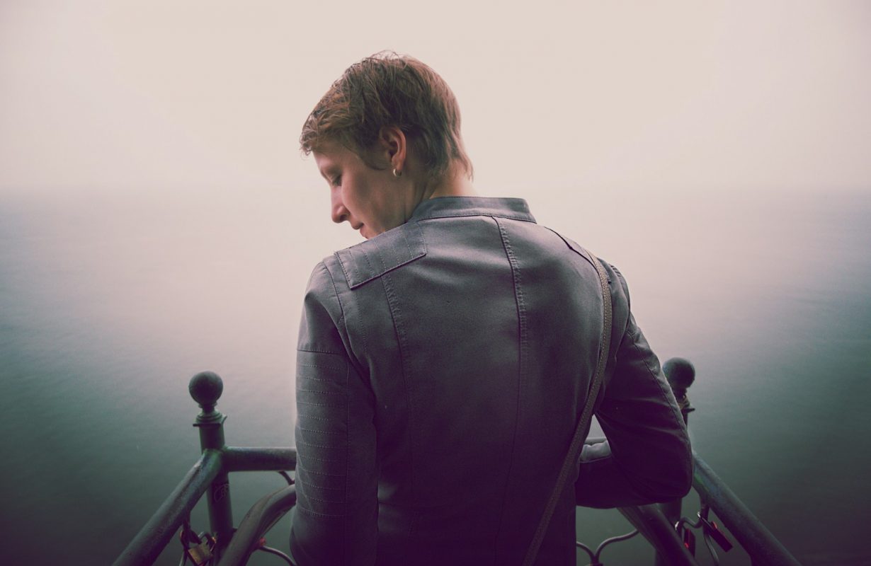 man standing beside black steel fence